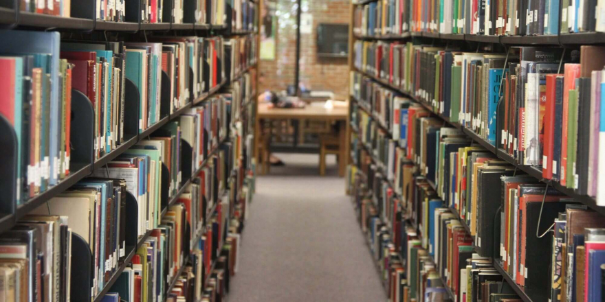 Photo of the walkway between two library book stacks