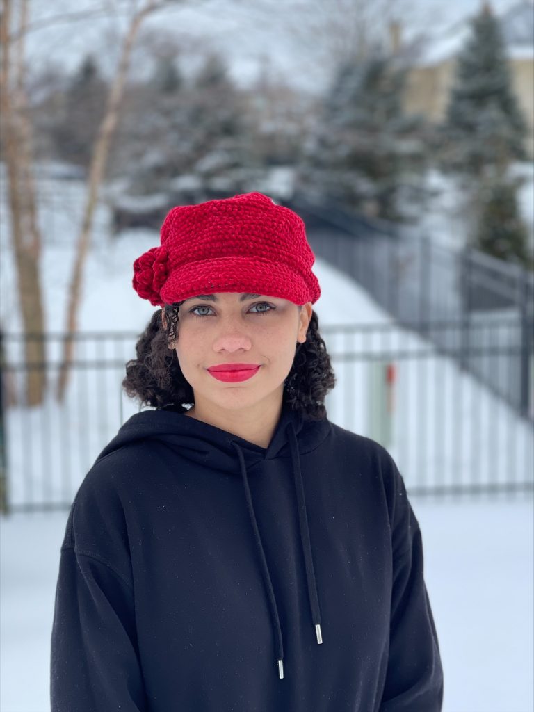 Nia Themelaras wearing a red hat with a snowy background