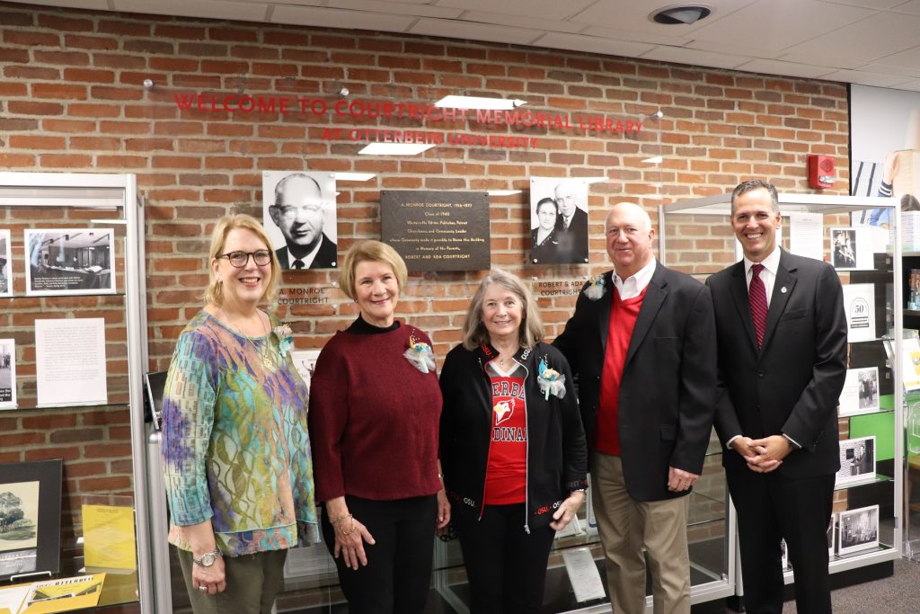 Members of the Courtright Family standing in front of the new donor wall with President Comerford