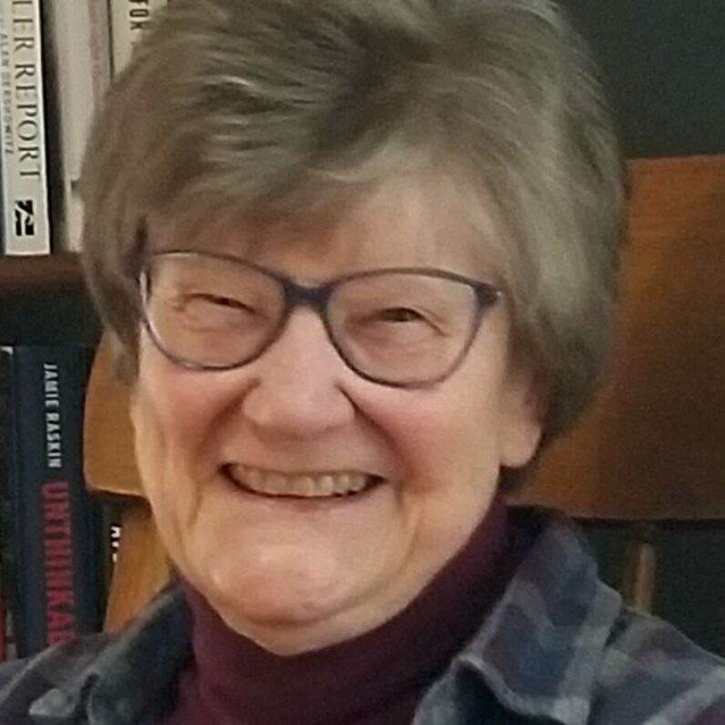 A photo of Dr. Beth Daugherty. She is a white woman with short hair with glasses. She is smiling at the camera.