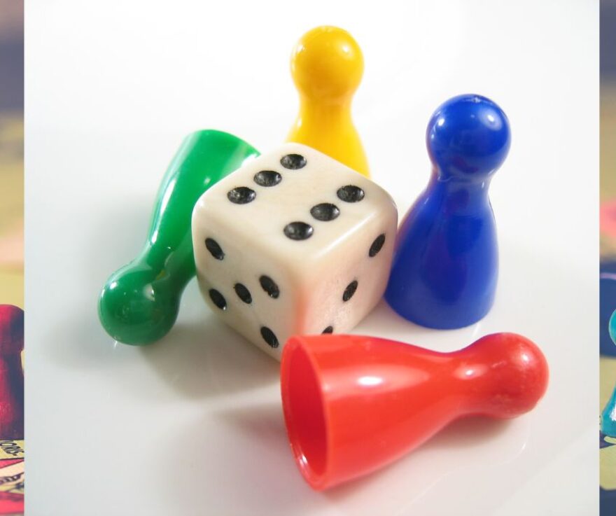 Board game pieces on a white background, including a die and four tokens.