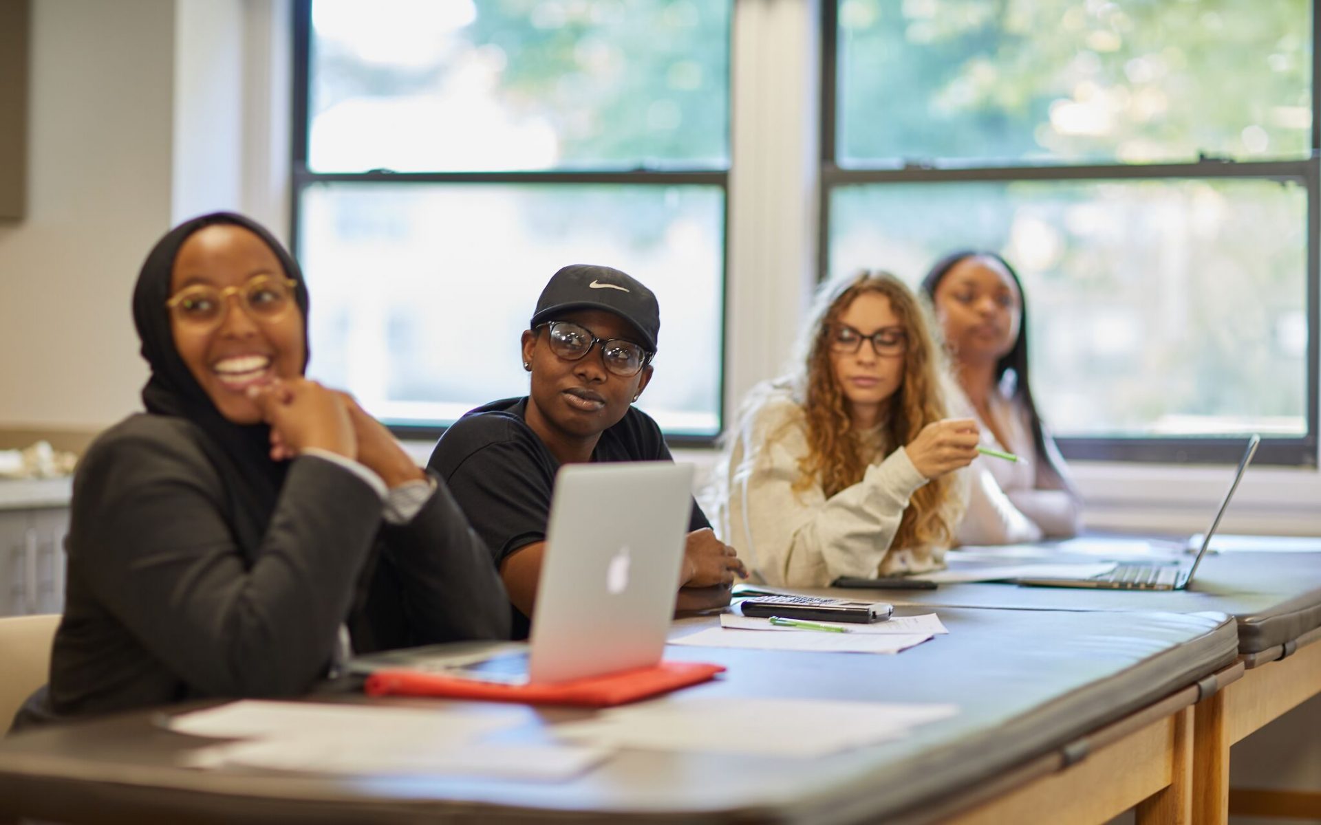 White, Black, and Brown Otterbein Students sit together in a classroom.