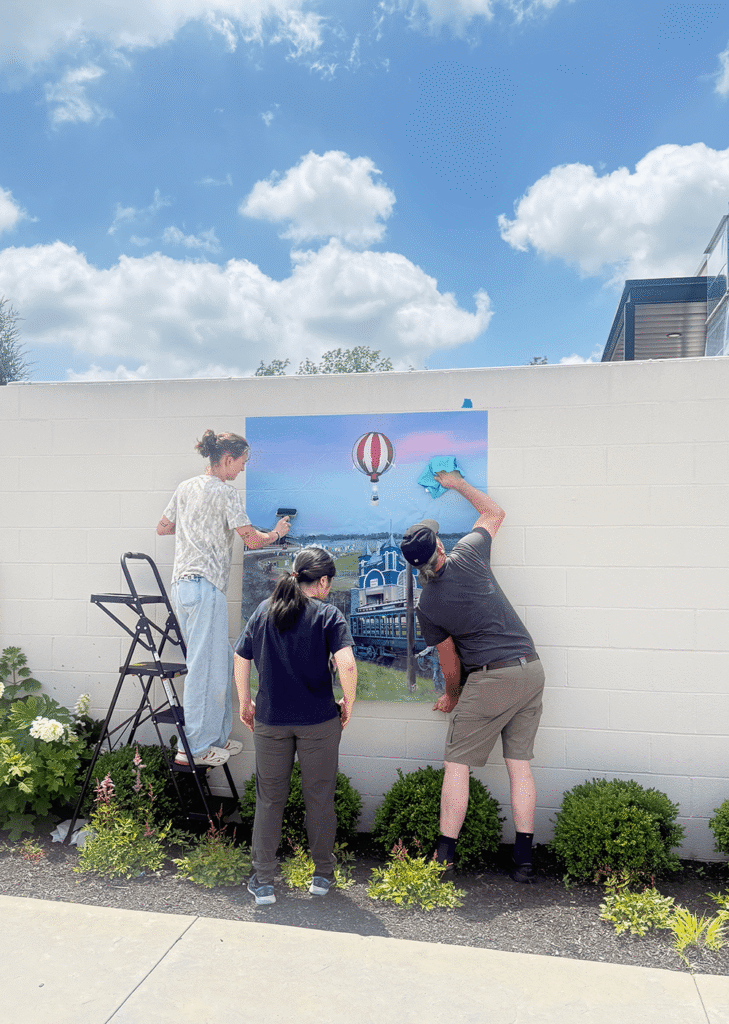 Otterbein Student Installing Vinyl Murals Designed To Honor The People Places And Perspectives That Have Shaped The Community