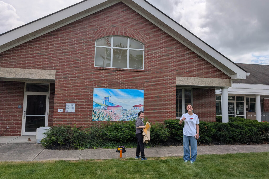Otterbein Student Infront Of Installed Vinyl Murals Made By Otterbein University Designed To Honor The People Places And Perspectives That Have Shaped The Community Jpg
